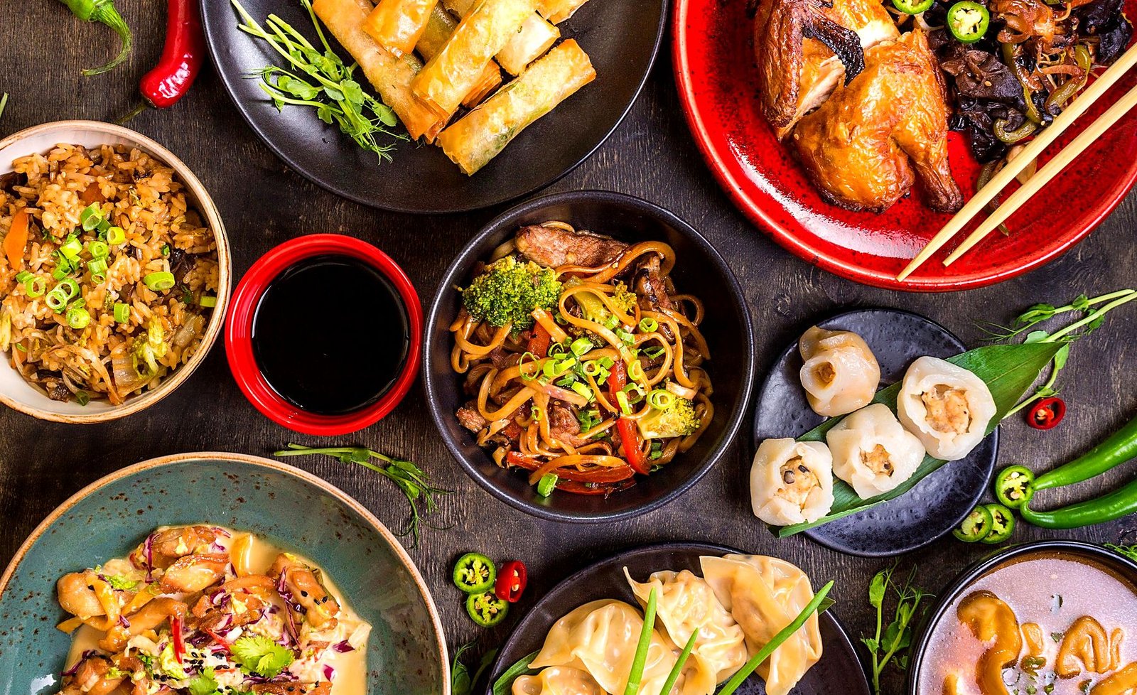 Spring rolls, fried rice, lo mein, dumplings and wonton soup on a table